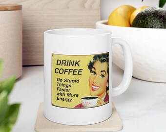 Peut inclure: Une tasse en céramique blanche avec un graphique vintage jaune et rouge qui dit "Drink Coffee Do Stupid Things Faster with More Energy". Une femme en robe rouge tient une tasse de café.