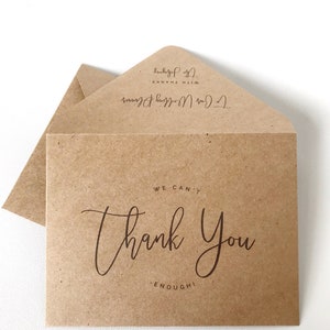 May include: Kraft paper thank you card with a matching envelope. The card reads "We can't thank you enough!" in elegant script. The envelope is addressed "To Our Wedding Planner" and "With Thanks, The Johnsons."
