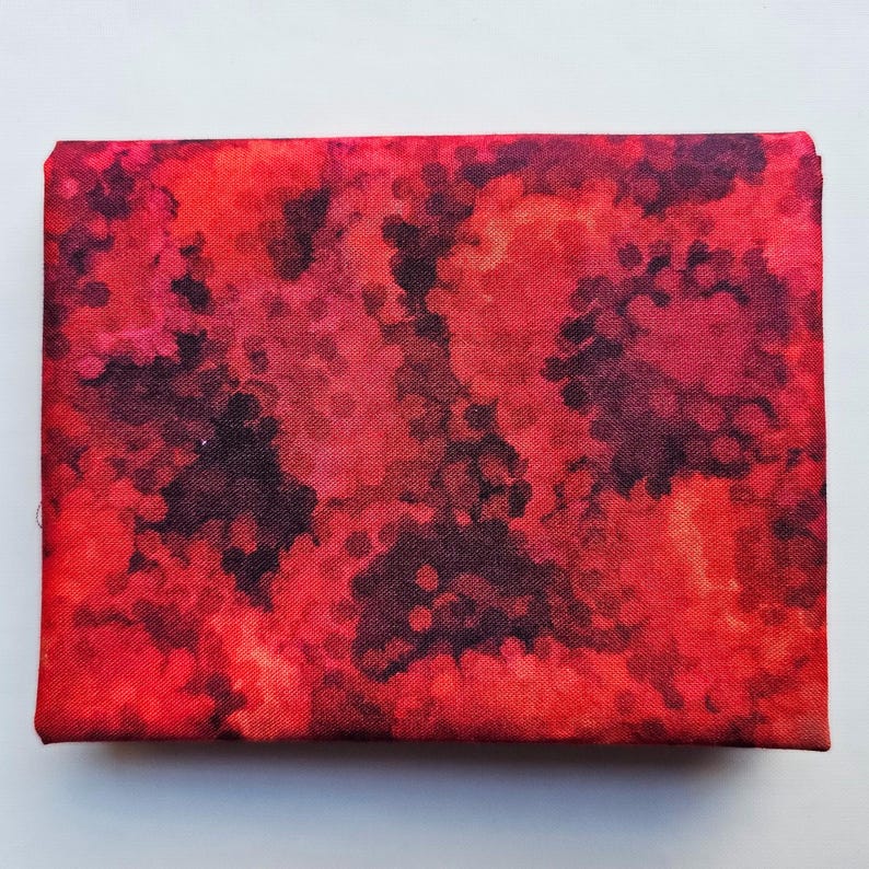 Op de afbeelding: Een rechthoekig canvas met een abstract ontwerp in tinten rood, karmozijnrood en zwart. Het kunstwerk heeft een textuur. Het canvas is gespannen en klaar om te worden tentoongesteld, geschikt voor interieurdecoratie.