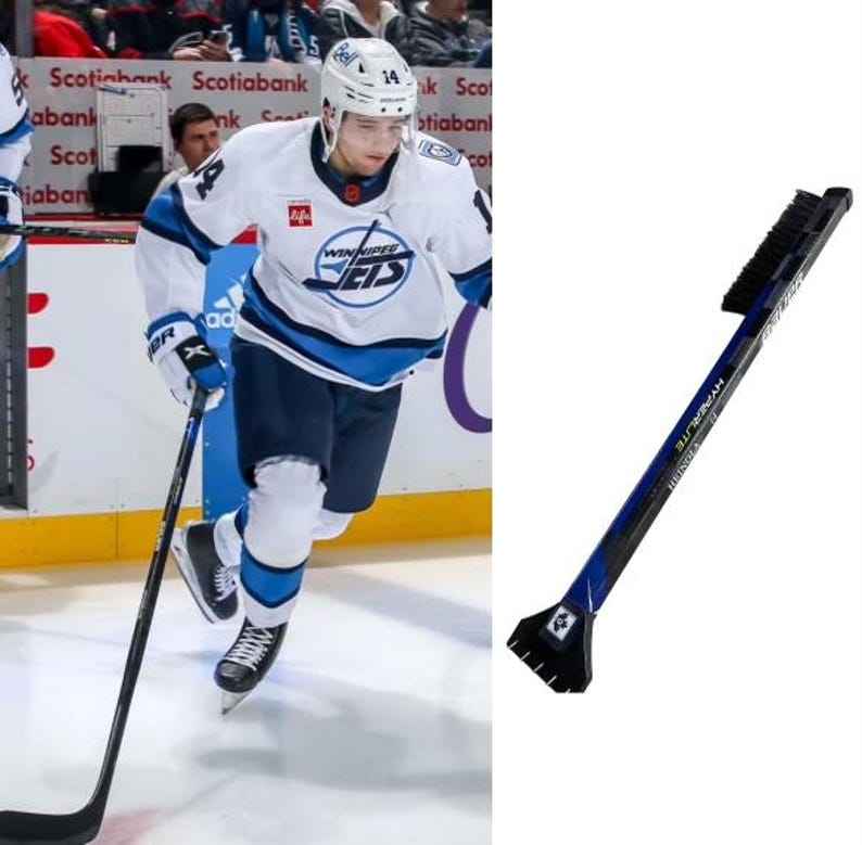May include: A hockey player wearing a white and blue jersey with the text "Winnipeg Jets" on the front, skates on the ice with a hockey stick. A blue and black ice scraper with a brush is shown on the right side of the image.