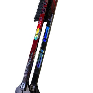 May include: Two hockey stick ice scrapers with black brushes and a black plastic scraper at the bottom. The sticks are red and black with the text "TRUE" and "STX" on them.