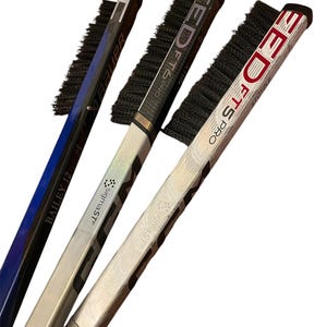 May include: Three hockey sticks with black brush attachments. The sticks are silver, black, and red with white text. The text on the sticks reads "EDTS PRO", "BAILEY 12", and "SigmaSTF".