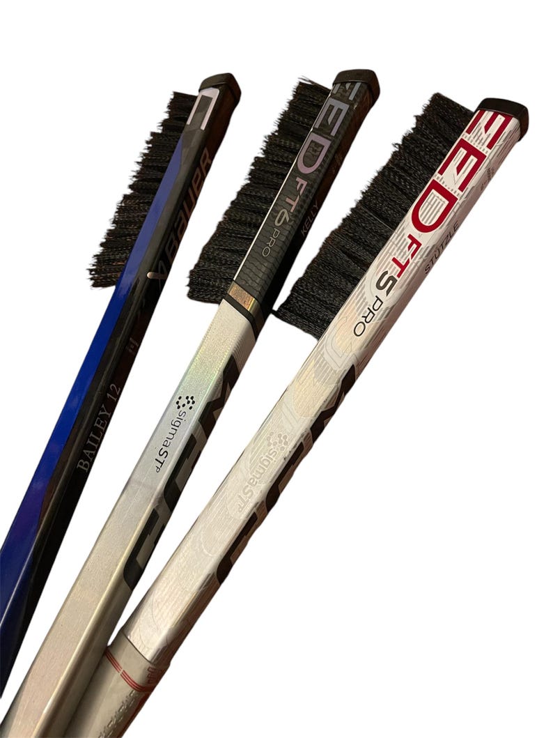 May include: Three hockey sticks with black brush attachments. The sticks are silver, black, and red with white text. The text on the sticks reads "EDTS PRO", "BAILEY 12", and "SigmaSTF".
