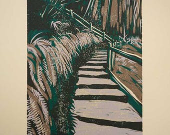 May include: A green and brown woodblock print of a stone staircase leading up into a forest. The print is signed "M. Shin" and numbered "7/12".
