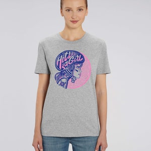 K&ouml;nnte beinhalten: Graues T-Shirt mit einer pinkfarbenen und blauen Grafik einer Frau mit Helm und dem Text "Hit like a girl".