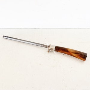 May include: A silver steel knife sharpener with a brown wooden handle.