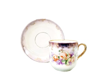 Tazza e piattino vintage in porcellana tedesca con decorazioni floreali viola smaltate.