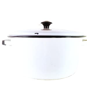Puede incluir: Olla de esmalte blanco con borde y tapa negros. La olla tiene dos asas laterales y un pomo negro en la tapa. Un artículo de cocina clásico.