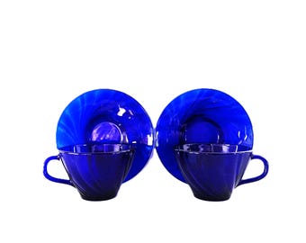 Par de tazas de café y té vintage francesas Rosaline Cobalt Arcoroc de vidrio con diseño de remolino y platillos a juego.