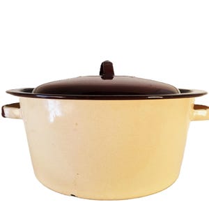 May include: Cream-colored enamel pot with a dark brown lid and rim. The pot has two side handles and a matching brown handle on the lid. A vintage kitchenware item.
