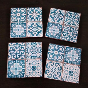 May include: Set of four blue and white ceramic coasters with a geometric pattern. Each coaster features a different design with a mix of blue and white colors.
