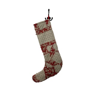 May include: A red and white quilted Christmas stocking with a floral pattern.