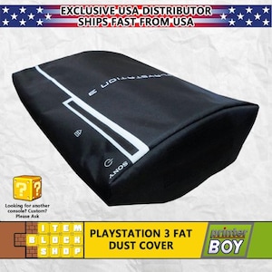 May include: Black dust cover for a PlayStation 3 Fat console. The cover has a white Sony logo and the words "PLAYSTATION 3 FAT DUST COVER" printed on it.