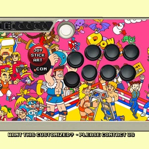 May include: A pink arcade joystick with a colorful design featuring cartoon characters and the text "JOY STICK ART .COM".