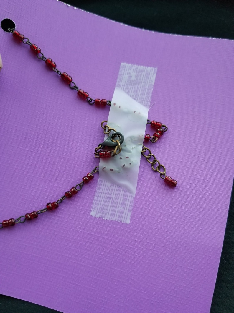 bronze wire with red beads with design charm in bronze and red beads Necklace
