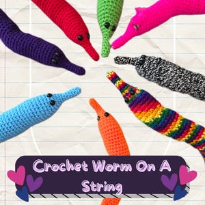 May include: A collection of colorful crochet worms, each with a distinct hue, including red, green, pink, purple, blue, orange, black and white, and rainbow. The worms have black button eyes and are arranged in a circular pattern. The image includes text that reads "Crochet Worm On A String."