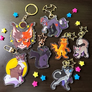 Peut inclure: Ensemble de dix porte-clés sur le thème du chat, de couleur vive, avec des anneaux dorés. Chaque porte-clés présente un design de chat différent avec des couleurs et des motifs uniques. Les porte-clés sont en acrylique transparent et ont une finition brillante.