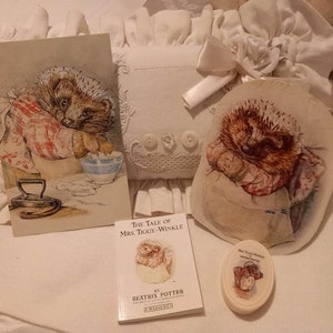 Può includere: Un set di articoli a tema Beatrix Potter con Mrs. Tiggy-Winkle, tra cui un libro, una cartolina, una toppa di stoffa e un piccolo sapone.