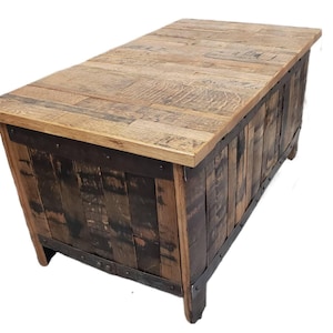 May include: A wooden coffee table made from reclaimed whiskey barrels. The top is made of light wood and the sides are made of dark wood. The table has a rustic look and is perfect for a farmhouse or industrial style home.