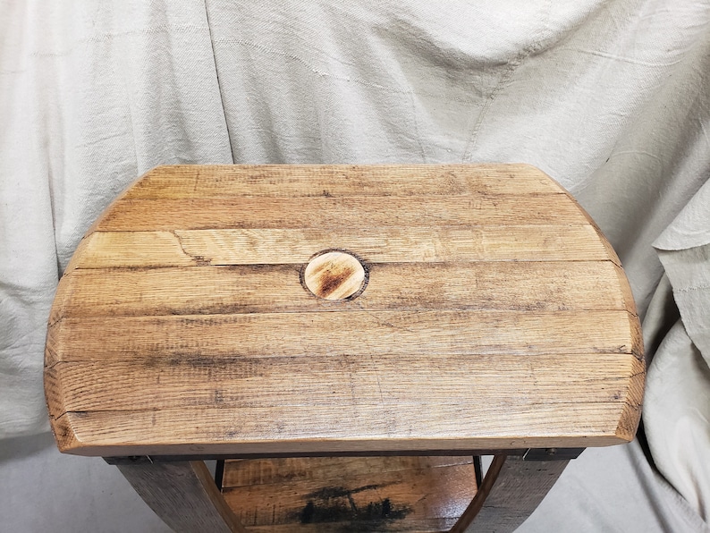 Pu&ograve; includere: Un tavolino rustico in legno con piano curvo in legno di recupero. Il piano presenta un inserto circolare ed &egrave; sostenuto da un telaio in metallo. Le dimensioni del tavolo sono di circa 76 cm di lunghezza, 46 cm di larghezza e 51 cm di altezza.