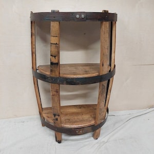 May include: A three-tiered shelf made from reclaimed wood barrel staves with metal bands. The shelf is a half-circle shape and has a rustic, farmhouse style.