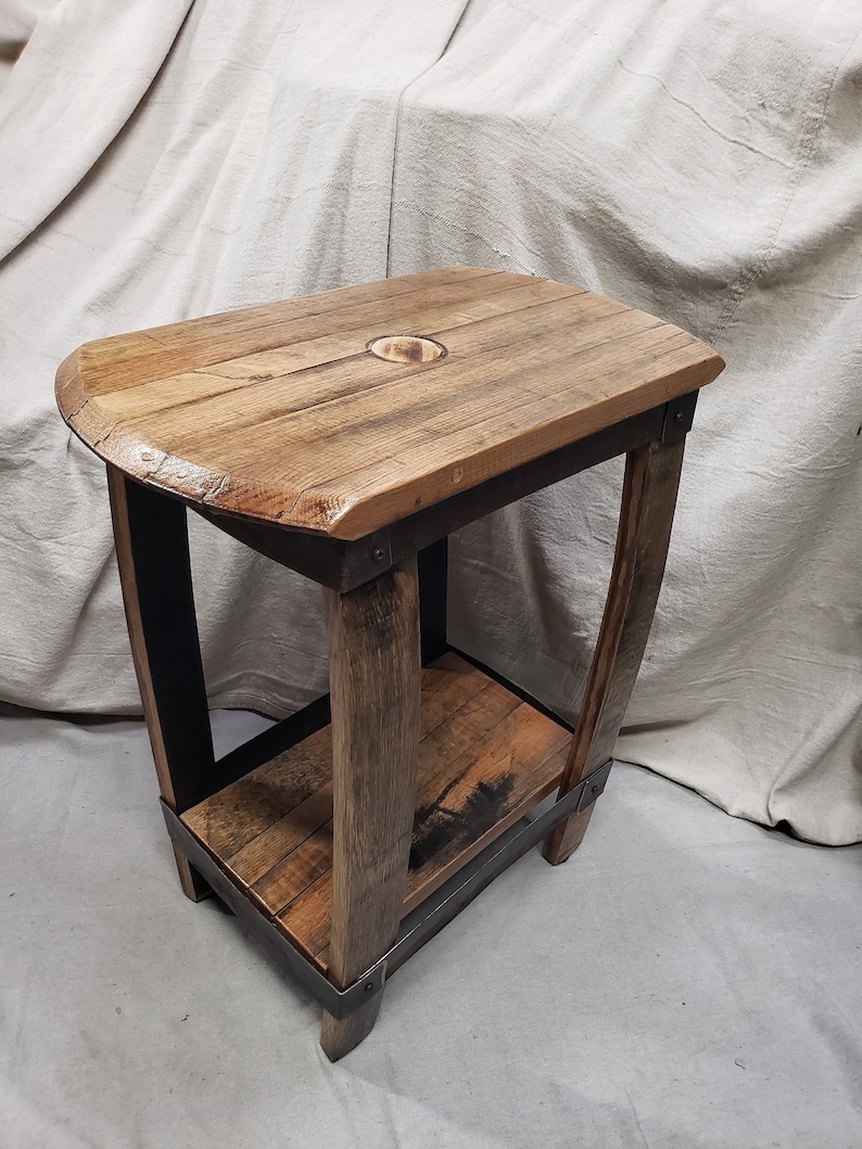 Pu&ograve; includere: Un tavolino rustico in legno con piano rettangolare e ripiano inferiore. Il tavolo &egrave; costruito con legno di recupero con venature a vista e finitura naturale. Il telaio &egrave; in metallo scuro. Il tavolo misura circa 61 cm di altezza.