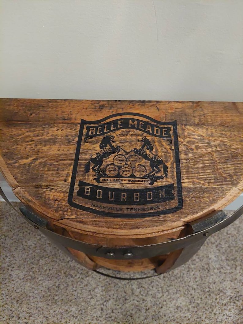 May include: A wooden barrel with a metal band, featuring a black and white label that reads "Belle Meade Bourbon, Small Batch - Handcrafted, Nashville, Tennessee".