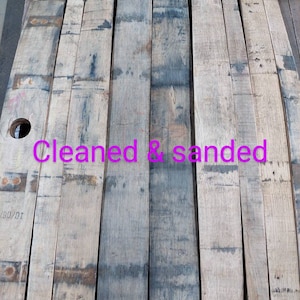 May include: Six wooden planks, cleaned and sanded, ready for a project. The planks are light brown with dark brown streaks and have a rough texture.