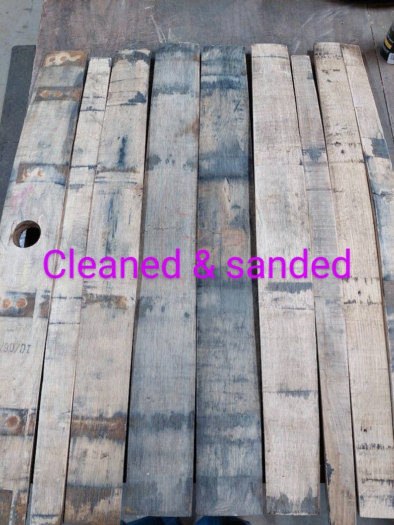 May include: Six wooden planks, cleaned and sanded, ready for a project. The planks are light brown with dark brown markings. The text "Cleaned & sanded" is written in pink on the planks.