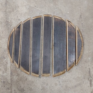 May include: A set of eight wooden barrel staves, arranged in a semi-circle, with the ends of the staves forming a rounded shape. The staves are dark brown with a light brown trim.