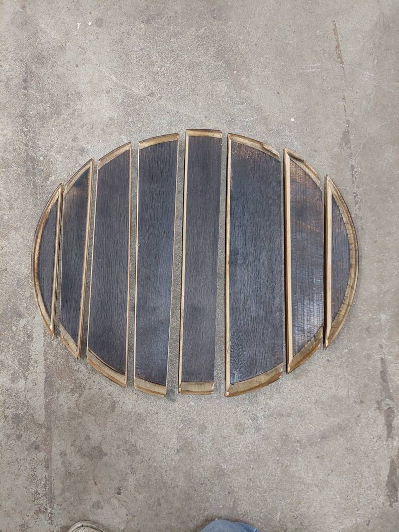 May include: A set of eight wooden barrel staves, arranged in a semi-circle, with the ends of the staves forming a rounded shape. The staves are dark brown with a light brown trim.