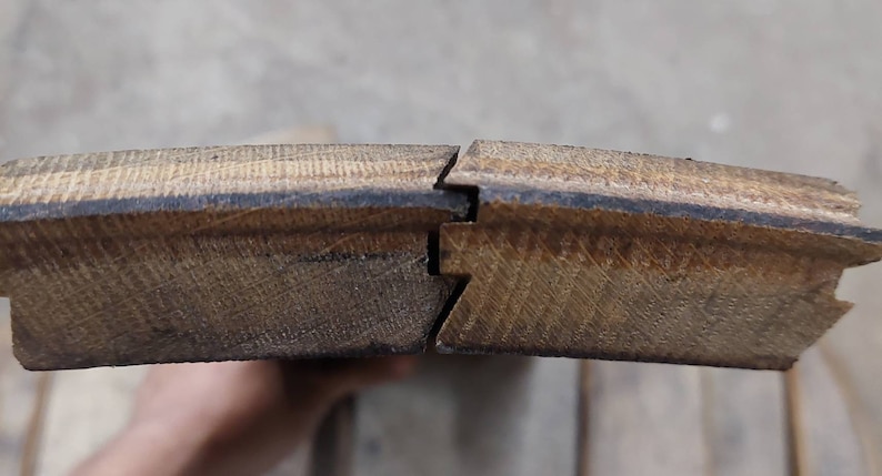 May include: Close-up of two pieces of wood flooring with a tongue and groove joint. The wood is a light brown color and has a natural grain pattern.