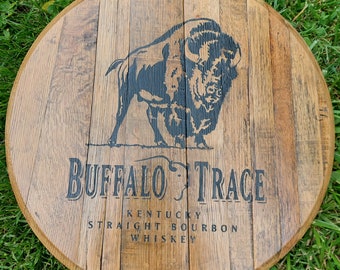 May include: A round wooden sign with a black buffalo silhouette and the text "Buffalo Trace Kentucky Straight Bourbon Whiskey".