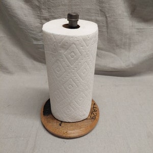 Könnte beinhalten: Ein Papierrollenhalter aus Holz mit einer Metallstange und einer Rolle Papierhandtücher. Der Halter hat ein eingebranntes schwarzes Design und den Text "41429" an der Seite.