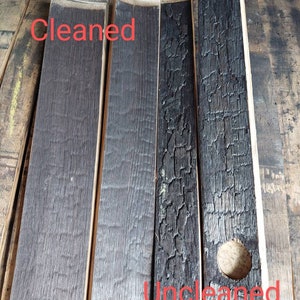 May include: Close-up of four wooden planks, two are charred and two are cleaned. The charred planks have a rough, uneven texture and a hole in one of them. The cleaned planks have a smooth, even texture. The text "Cleaned" is written on the left side of the image and "Uncleaned" is written on the right side of the image.