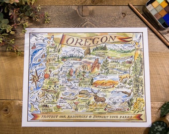 May include: A colorful illustrated map of Oregon with the text "OREGON" in a banner at the top. The map features various landmarks, animals, and natural features of the state, including mountains, forests, rivers, and the Pacific Ocean. The text "PROTECT OUR RESOURCES & SUPPORT YOUR PARKS" is at the bottom of the map.
