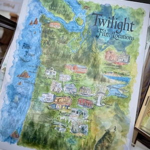 Könnte beinhalten: Aquarell-Landkarten-Druck mit Twilight-Drehorten in Oregon und Washington. Die Karte zeigt den Pazifik, Vancouver Island und verschiedene Sehenswürdigkeiten. Der Text enthält "Twilight Film Locations", "Portland" und "Oregon". Ein heulender Wolf ist abgebildet.