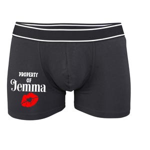 May include: Black boxer shorts with a white waistband and the text "PROPERTY OF Jemma" with a red lip print.
