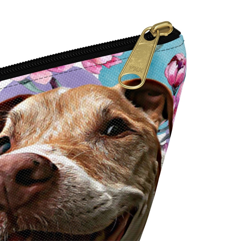 Puede incluir: Primer plano de la cara de un perro marr&oacute;n y blanco con un fondo azul y flores rosas. El perro mira a la c&aacute;mara con una expresi&oacute;n feliz. La imagen est&aacute; impresa en una bolsa con cremallera.