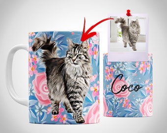 May include: White ceramic mug featuring a detailed illustration of a fluffy cat with green eyes, set against a blue floral background with pink roses. A small polaroid-style image of the cat is pinned nearby. The mug is decorated with the name "Coco".