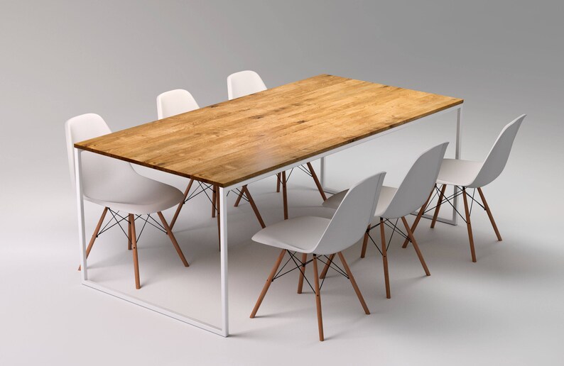 May include: A rectangular wooden dining table with a light brown finish, supported by a white metal frame. Six white plastic chairs with wooden legs and black wire supports surround the table, creating a modern dining set.