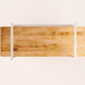 Puede incluir: Una mesa de madera con un marco de metal blanco. La mesa est&aacute; hecha de madera clara con un patr&oacute;n de veta natural.