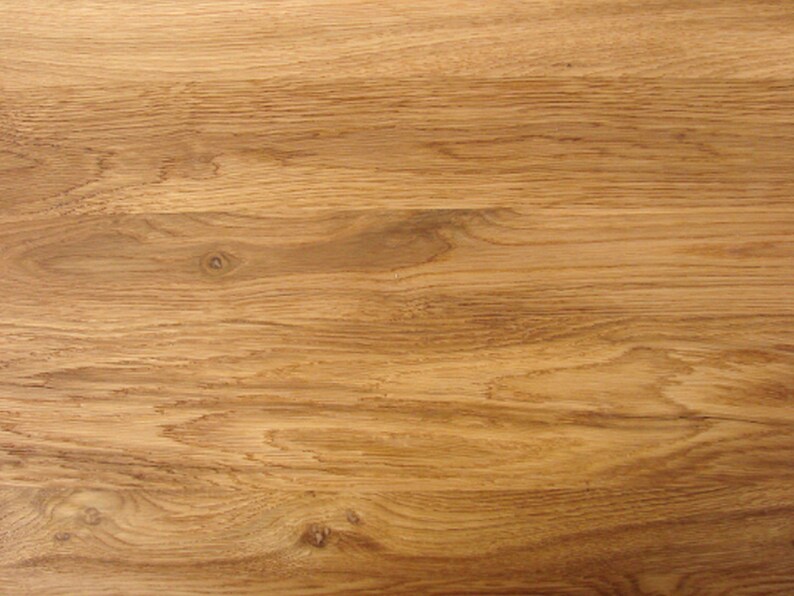 May include: Close-up of a light brown wood grain surface. The wood has a natural, warm tone and a smooth texture.
