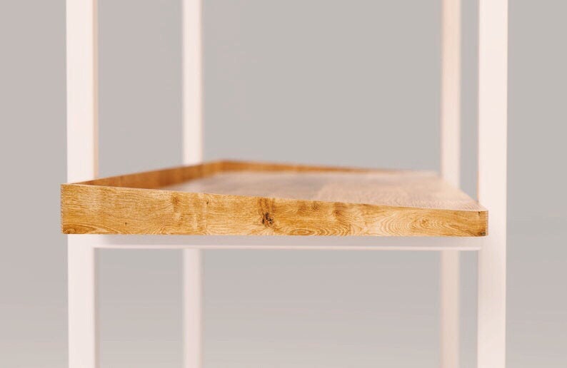 Puede incluir: Una estanter&iacute;a de metal blanco con un estante de madera. El estante est&aacute; hecho de madera natural de color marr&oacute;n claro y tiene una textura ligeramente rugosa.