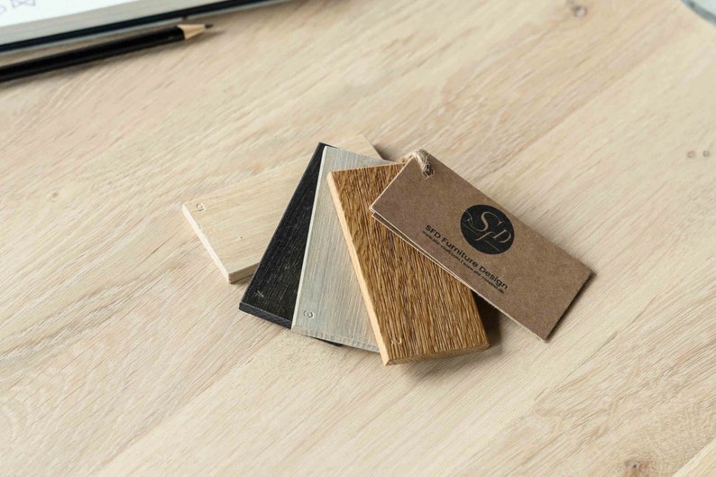 May include: Four wood samples in different shades of brown, black, and white, with a brown tag that reads "SFD Furniture Design".