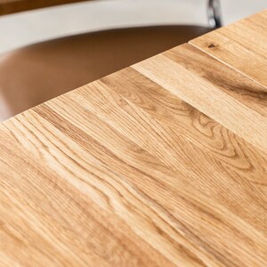K&ouml;nnte beinhalten: Nahaufnahme einer hellbraunen Tischplatte aus Holz mit nat&uuml;rlicher Holzmaserung. Die Tischplatte besteht aus mehreren zusammengef&uuml;gten Holzbrettern.