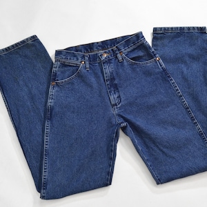 May include: A pair of blue denim jeans with a classic straight leg fit. The jeans have a button fly and five pockets.