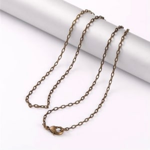 May include: A bronze chain necklace with a lobster clasp closure.