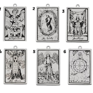 May include: Six silver pendants with black and white illustrations of tarot cards. The cards are: Judgement, The World, Justice, The Tower, Temperance, and Wheel of Fortune.