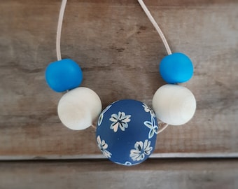 Wood and clay necklace with blue floral bead